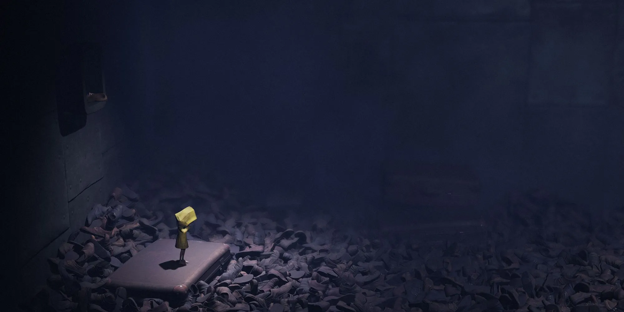 Six bị bao quanh bởi những đống giày trong căn phòng thiếu sáng, bối cảnh quen thuộc trong Little Nightmares.